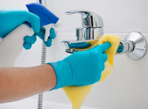 Cleaner resetting a guest-ready bedroom for an Airbnb in NW5
